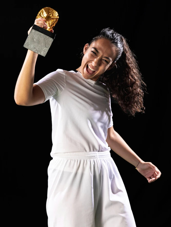 mulher comemorando com troféu na mão